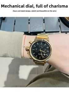 Detail of a gold stainless steel watch with a black multi-dial face on a female wrist