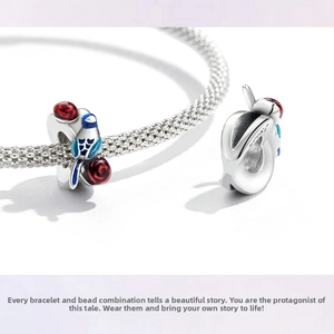 Macro shot of S925 sterling silver mesh bracelet with bird and rose enamel charms