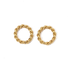 Detail of gold twisted hoop earrings with a mirror-polished texture and geometric design