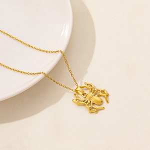 Detailed view of golden spider pendant with matte texture on stainless steel chain