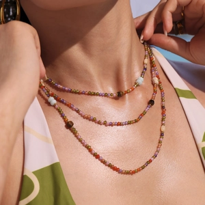 Three-layer bohemian beaded necklace with colorful stones and golden accents on a model