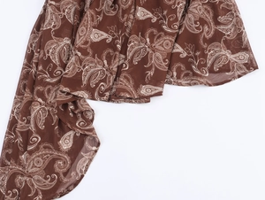 Dettaglio del tessuto in chiffon marrone con motivo paisley bianco e morbida trama a pieghe