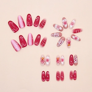 Detail of floral press-on nails featuring 3D butterfly patterns and pearl accents