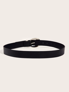 Detail of a vintage black leather belt featuring a silver rhinestone oval buckle on beige background