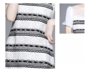 Detail of white lace dress featuring black hollow lace trim and rhinestone neckline