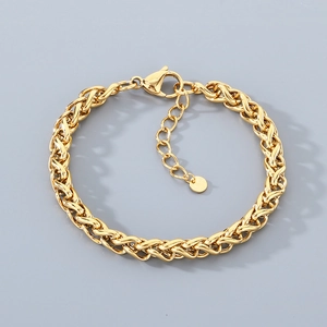 Vue macro d'un bracelet en maille tressée dorée avec fermoir mousqueton et pendentif rond