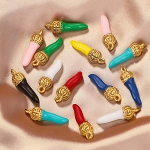 Chic enamel horn pendants with gold caps scattered on beige satin for DIY jewelry