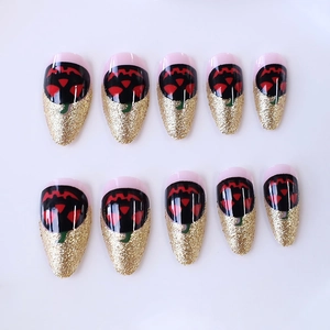 Halloween almond nails featuring Jack-o'-lantern design and gold glitter gradients