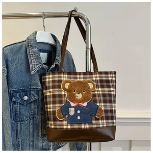 Detail of plaid tote bag with brown faux leather bottom and cute bear embroidery