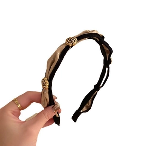 Elegant camellia headband featuring beige and black woven fabric with gold roses and crystals