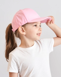 Detailed side view of a pink children's baseball cap worn by a young child model outdoors