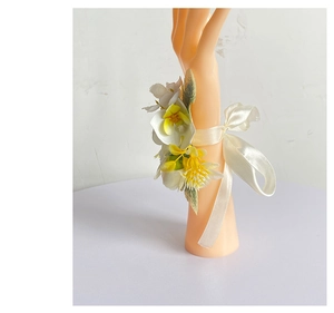 Close-up of artificial white and yellow rose wrist corsage with silk ribbon on wrist