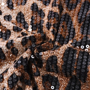 Macro shot of stylish leopard print fabric with shimmering sequins and soft texture