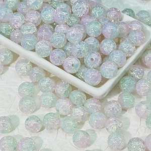Macro detail of 10mm iridescent crackle glass beads in pastel gradient for DIY jewelry