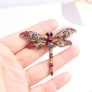 Macro shot of a vintage dragonfly brooch with multicolored rhinestones on a hollowed base