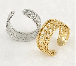 Detailed view of hollow leaf pattern on gold and silver stainless steel open rings