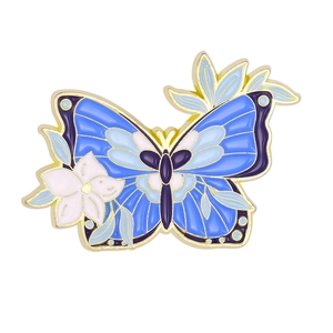 Macro d'une broche papillon en émail bleu avec fleurs blanches et bordure dorée