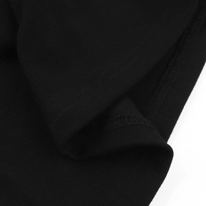 Detailed close-up showing the double-stitched hem on a black knit cotton long sleeve top