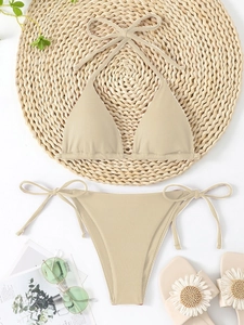 Beige ribbed bikini set with halter triangle top and side-tie bottoms on a beach mat