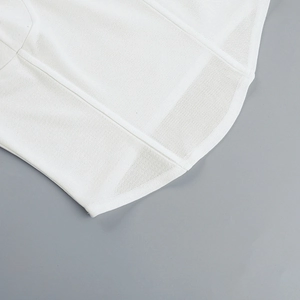 Detailansicht aus weißem Strickstoff und atmungsaktivem Mesh mit feinen Nähten am Saum