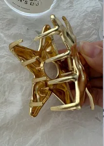 Detailed view of a large gold star hair claw clip with a glossy textured finish