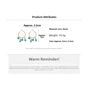 Detail view of ethnic hoop earrings with turquoise stones and gold metal tassels