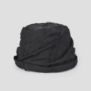 Detail showing the distressed torn edge texture and black fabric of this fisherman bucket hat