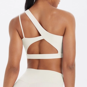 Detail of cream white sports bra featuring asymmetric straps and open back cutout design