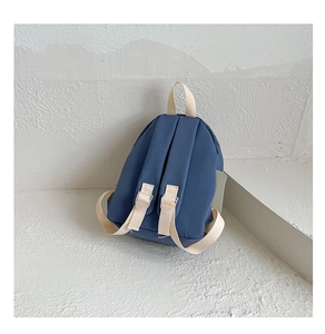 Rear view of a blue nylon kids backpack featuring white webbing straps and handles