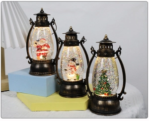 Three bronze Christmas snow globe lanterns with Santa, snowman and tree figurines