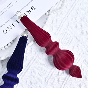 Elegant conical velvet Christmas ball ornaments in red and blue on a knitted background