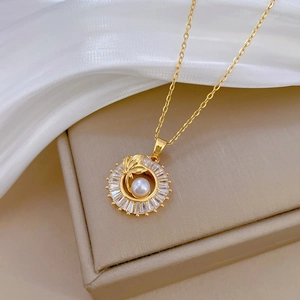 Macro view of gold necklace pendant with central pearl and sparkling zircon halo