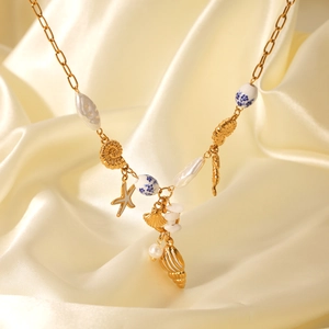 Gold starfish shell pearl charm necklace on silk fabric with paperclip chain design