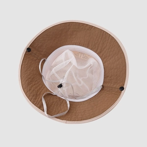 Detail view of breathable white mesh lining and adjustable chin strap on sun hat