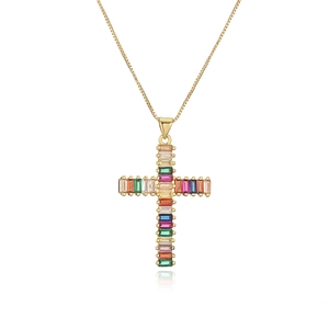 Macro detail of gold-plated cross pendant featuring multicolored rainbow zircon stones