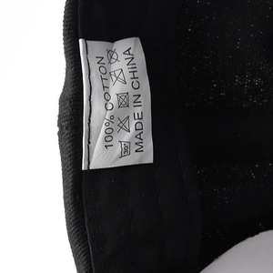 Detail of internal care label on cotton NYC hip-hop hat showing 100% cotton and wash icons