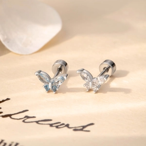 Elegant silver butterfly stud earrings with blue and white crystals on a soft background