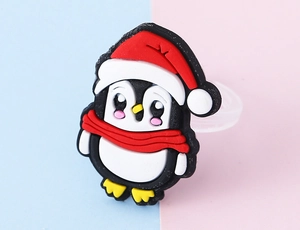 Makroaufnahme eines Pinguinrings mit Weihnachtsmütze und Schal für Kinder