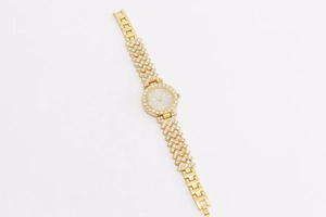 Close-up of golden floral watch with crystal rhinestones on polished metal band