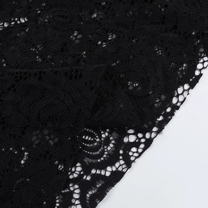 Gros plan sur le tissu en dentelle noire avec broderie florale complexe et résille