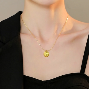 Collier en acier titane doré avec pendentif Fu ajouré, présenté sur un mannequin