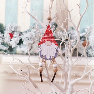 Close-up of wooden gnome Christmas ornament with red snowflake hat on white branch