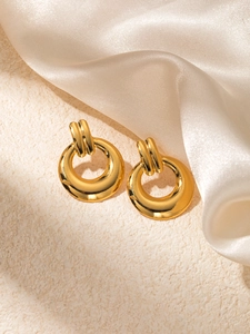 Vue macro de boucles d'oreilles créoles dorées vintage avec détails en relief sur soie
