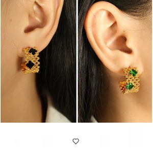 Détail de boucles d'oreilles C dorées avec texture grille et zircons carrés sertis
