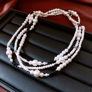 Détail d'un collier de perles multicouche avec perles noires sur plateau à bijoux