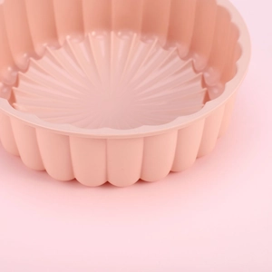 Close-up of pink silicone sunflower cake mold with inner wavy and radial patterns