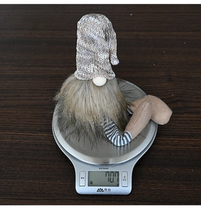 Detailed view of a Christmas gnome figurine on a digital scale showing its 70.7g weight