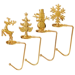 Set of four gold metal Christmas stocking mantle hooks with reindeer and snowflake motifs