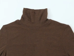 Close-up of neckline stitching and knit texture on brown turtleneck short sleeve top