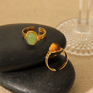 Detailed view of vintage gold-tone oval rings with tiger eye and green stone inlay